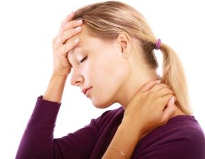 Woman in discomfort holding her head and neck.